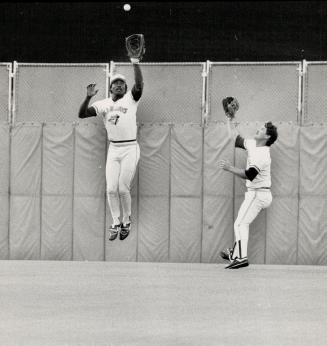 Eye on the ball: Blue Jay centre fielder Lloyd Moseby gets to this bouncing ball off the bat of Mel Hall ahead of teammate Rick Leach but not before the Cleveland left fielder reached second base