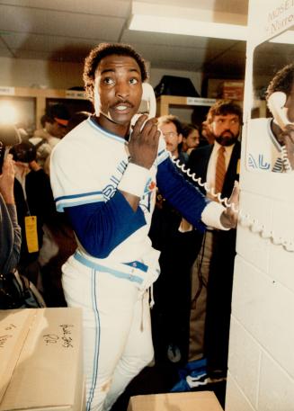 Lloyd Moseby, left, talks about game on telephone