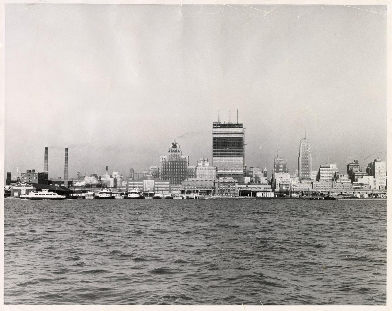 Image shows a lake view with skyline of Toronto in the background.