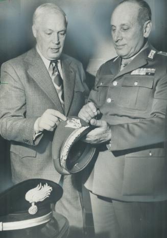 Italian Police visit Metro. Maj.-Gen. Alfredo Arnera (right) of the Carabinieri, the Italian national police, explains his cap emblem to Deputy Chief (...)