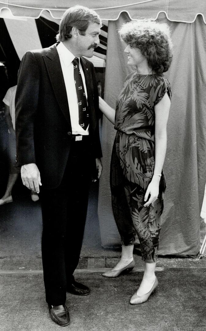 Lily Gaistman, of the Diamond Information Centre, and former tennis star John Newcombe, right, a spokesman for DeBeer's, enjoy the sunshine. Gaistman wears an ensemble by Thalie