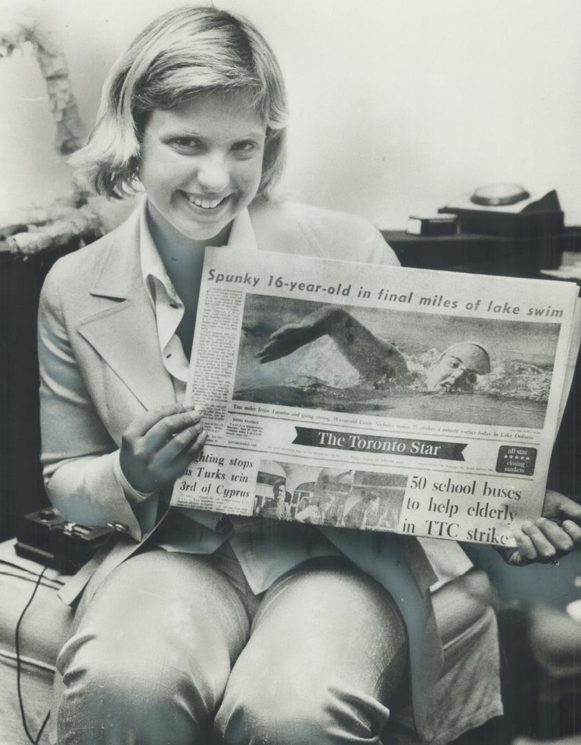 Relaxed swimmer Cindy Nicholas proudly displays front-page picture of herself in yesterday's final edition of The Star, taken only a few hours before (...)