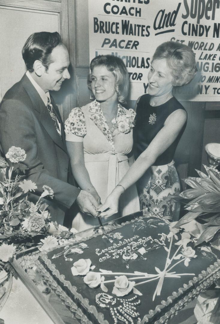 Belatedly celebrating her 17th birthday, Cindy Nicholas, who swam across Lake Ontario last month, gets help from her parents, Mr. and Mrs. Jim Nichola(...)