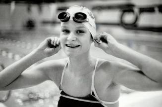 Dunking for gold, Anne Ottenbrite, the 17-year-old swimming sensation from Whitby, adjusts swim cap for another practice heat. Ottenbrite, a good bet (...)