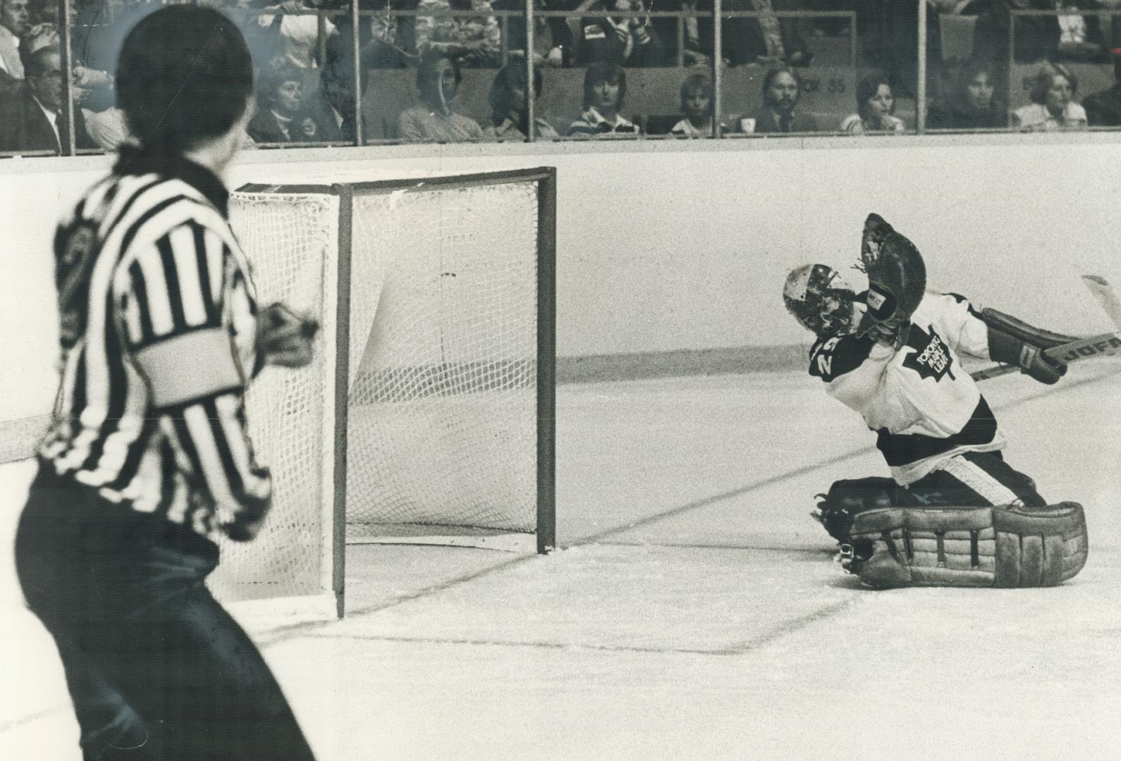 and, below, Leaf goalie Mike Palmateer, his gloves stil lin air from desperate grab at MacLeish's overtime shot, looks back into net. MacLeish (19) sc(...)