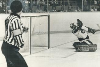 and, below, Leaf goalie Mike Palmateer, his gloves stil lin air from desperate grab at MacLeish's overtime shot, looks back into net. MacLeish (19) sc(...)