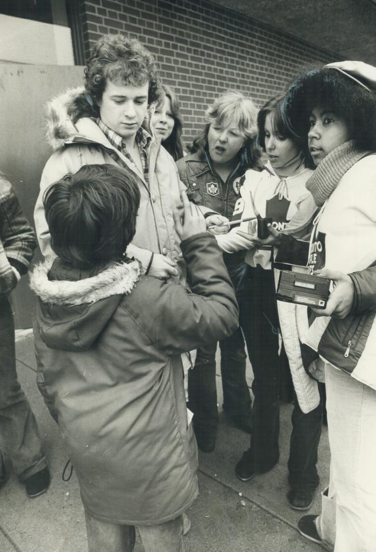 Still their hero, Maple Leaf goaltender Mike Palmateer is surrounded by autograph seekers after the team practised yesterday morning