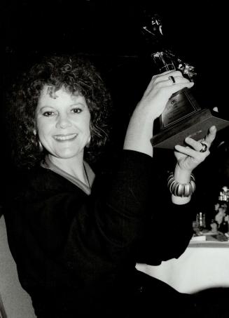 Media award, Above, fashion writer Catherine Patch holds high the Judy presented to The Toronto Star for excellence in coverage of the Canadian fashion industry in a print medium