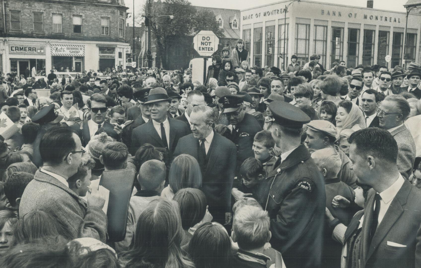 Prime Minister Pearson is surrounded by enthusiastic admires as he makes his way through St