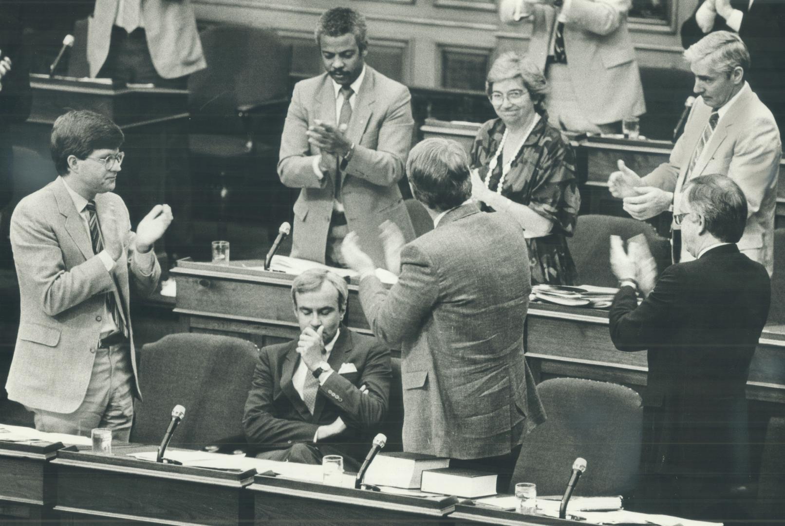 A seated Premier David Peterson receives a hearty round of applause from fellow Liberals in the Legislature yesterday after Bill 94 passes