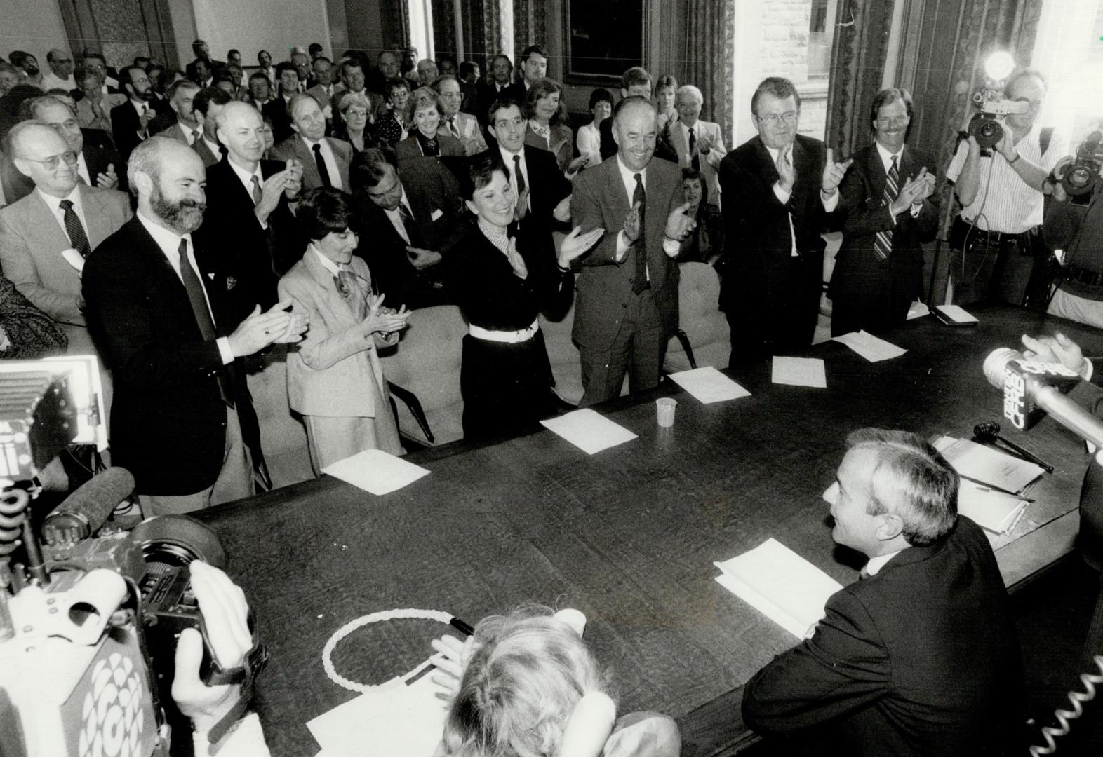 Conquering hero, Premier David Peterson is applauded by his new Liberal party caucus at Queen's Park yesterday