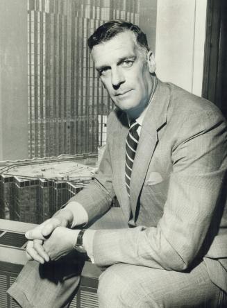 Tall and tough Ward C. Pitfield, shown in Toronto office with new Royal Bank building in background, took over today as new chairman of Investment Dealers Association at its annual meeting in Jasper