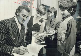 Happy youngsters, Paul Bubovich, 11, left, Davie Innes, 10, centre, and Danny Smith, 10, smile as their hero, goalie Jacques Plante of Leafs, autograp(...)