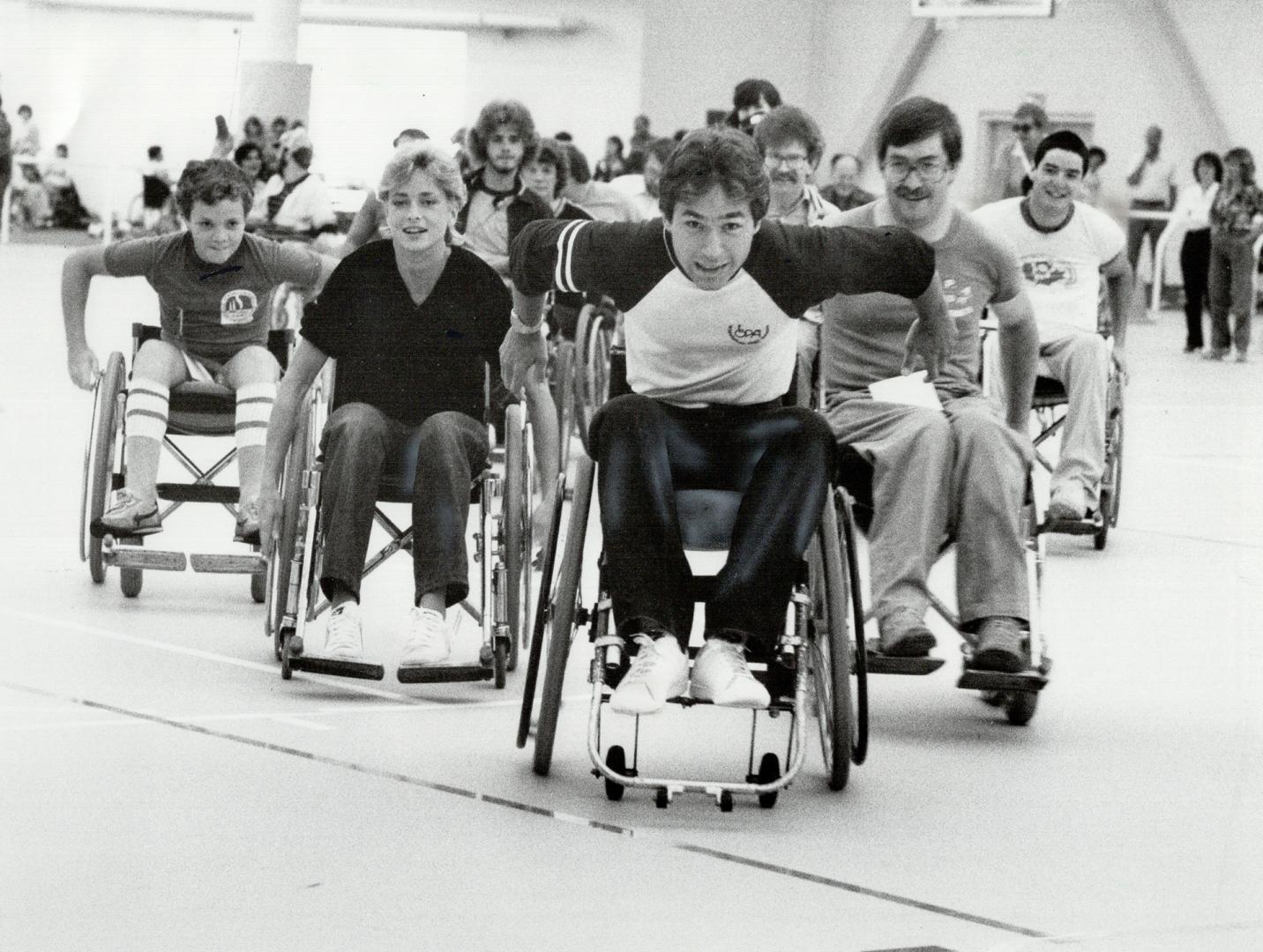 Going for it, Steve Podborski, Canada's World Cup downhill ski champion, is leading the pack in this Wheelathon 82 race at Variety Village in Scarboro(...)