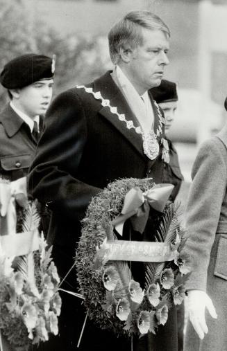 Below, Oshawa Mayor Jim Potticary stands silent, ready to present a wreath, as he waits his part in the day of mourning for those who gave their lives in two world wars