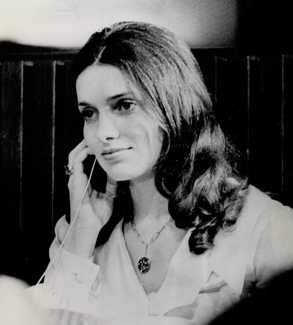 Listening to her Master's voice-Seated in the back row at her husband's press conference, Margaret Trudeau, holds an earphone as she listens to him speaking in French