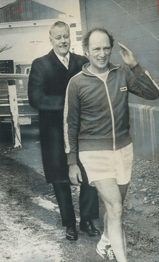 In shorts and red jogging shoes, Prime Minister Pierre Trudeau returns from an early morning jog, followed by a security man, during his whistle-stop tour of seven Maritimes communities