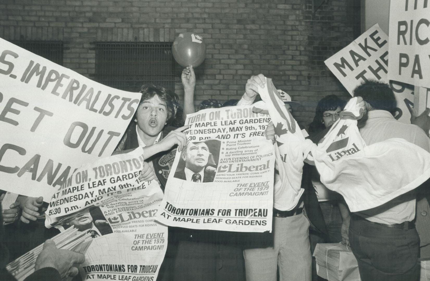 Kid in centre with Trudeau paper and guy waving Liberal T-shirts were part of a group who were heckling the Marxist Leninist people as they demo outside Maple Leaf Gardens