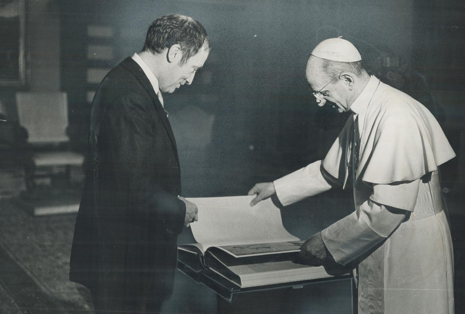 Pope Paul inspects book presented to him by Prime Minister Trudeau during visit to Vatican on Thursday when they discussed possible diplomatic exchange. Now Trudeau will probe public opinion