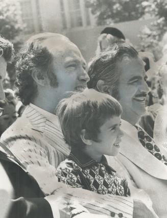 Watching international dancers in Nathan Phillips Square in the Dominion Day celebration Saturday, Effie Samios, 7, sits on Prime Minister Pierre Trud(...)