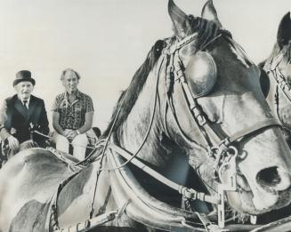 Prime Minister Pierre Trudeau rides shotgun on a wagon to reach a western-style barbecue given by the Alberta government last night at Heritage Park, (...)