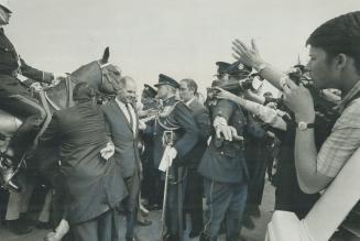 Hemmed in by crowd during visit to Toronto's Sir Casimir Gzowski Park Saturday, Prime Minister Pierre Trudeau is shielded from crush by line of standi(...)