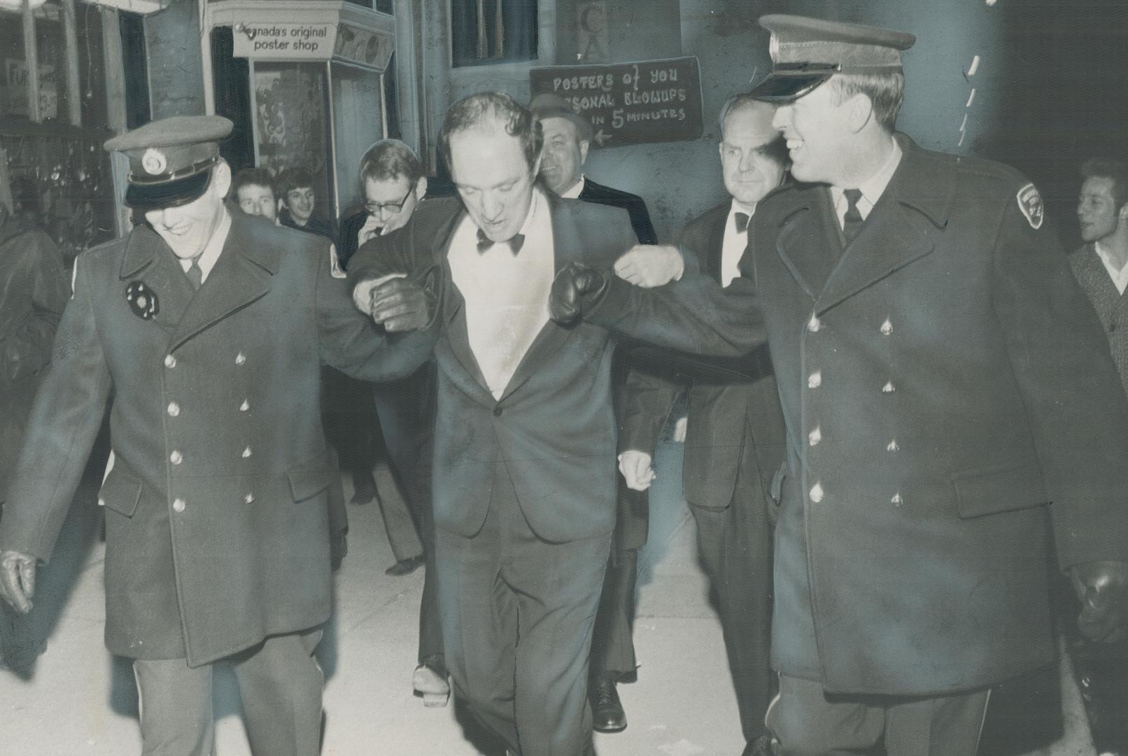 Partying through Yorkville on Saturday as part of his own personal Grey Cup celebration, Prime Minister Pierre Trudeau latches onto arms of two escort(...)