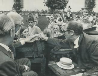 Trudeaumania in action: A young girl reaches out to touch Prime Minister Pierre Trudeau as he arrived in Toronto today to officially open the 91st Canadian National Exhibiton