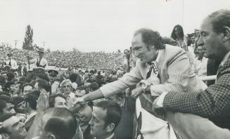 Greeting a friendly crowd at the soccer game, Prime Minister Trudeau smiles and shakes more hands