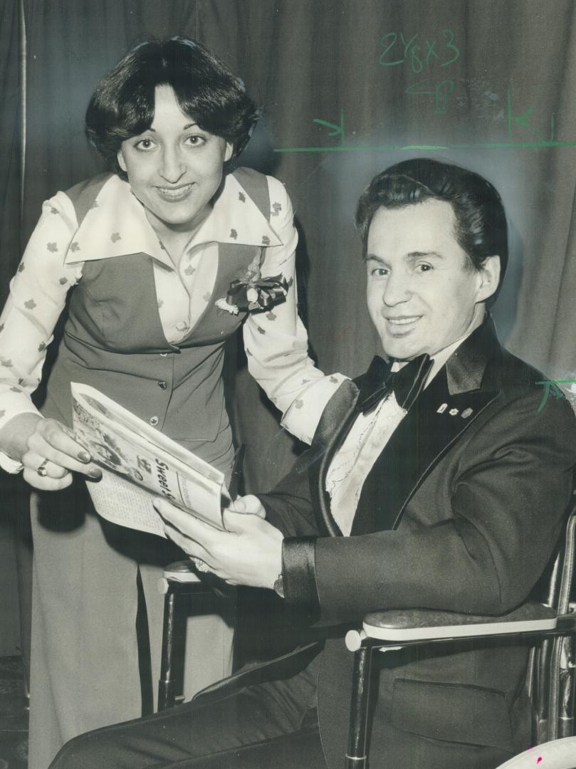 Maple Leaf Gardens usherette Marie Fabrizio, 23, looks over program with Ron Turcotte