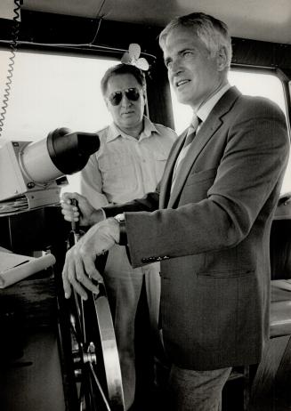 Prime Minister John Turner takes the wheel of the ferry here on his way to a rally