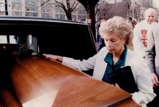 Touching goodbye: Elieen Watson, widow of 'Whipper Billy' Watson, pauses to place a rose on her husband's casket at the funeral yesterday