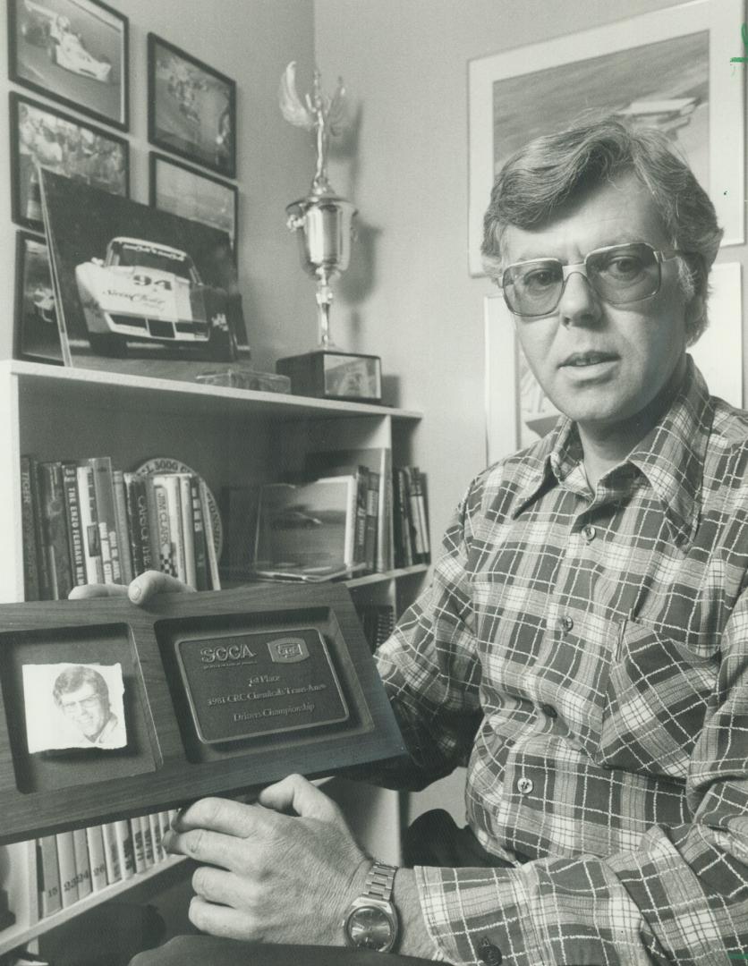 Latest trophy: Eppie Wietzes, in the trophy room of his Willows home, displays the plaque which he won by capturing the Trans-Series this year after his return to racing