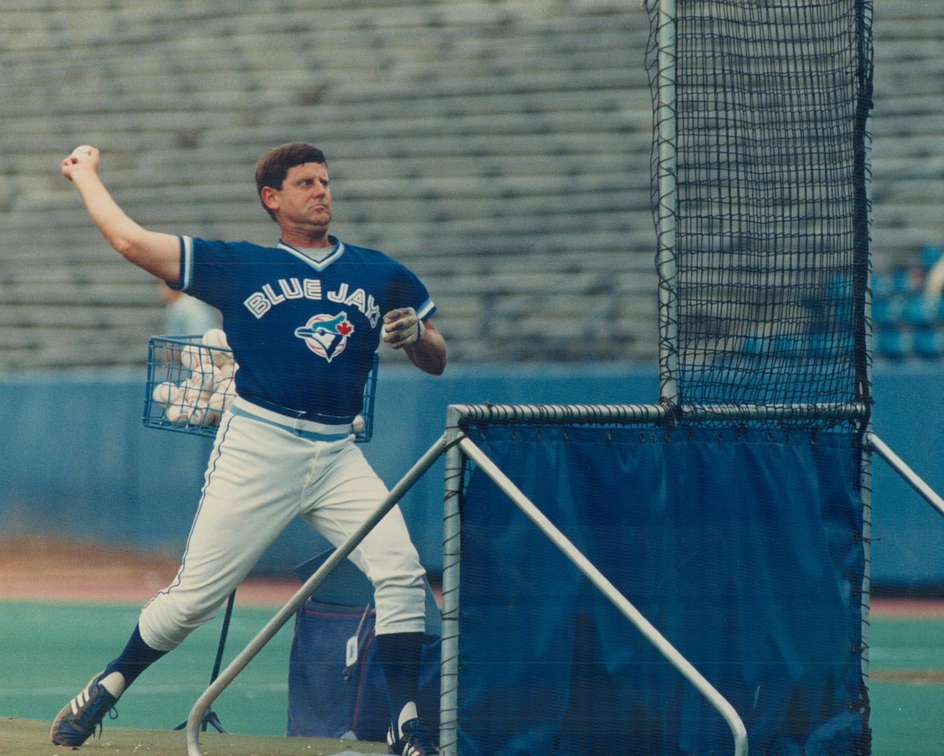 Coach John Sullivan (above) fills up the pitching hopper so his boss Jimy Williams can pitch batting practice