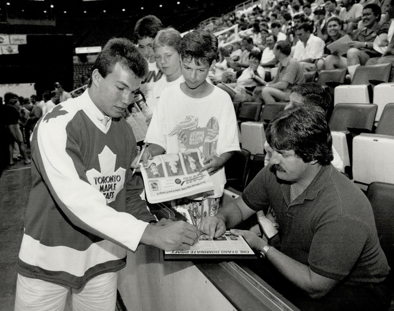 Richardson gets a taste of the big time, left, as he signs autographs for young fans on draft day in Detroit