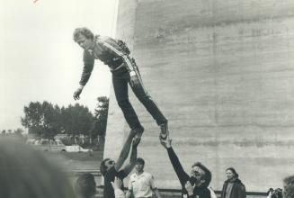 Ground crew rushes to help lower Robinson at the end of successful jump