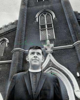 Rev. Harry Robinson, rector of Little Trinity Anglican Church, is shown in front of the 125-year-old King St. E. building gutted by fire in 1961. Inte(...)