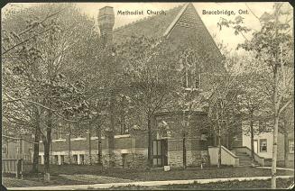 Black and white photograph of a brick church in a small town.