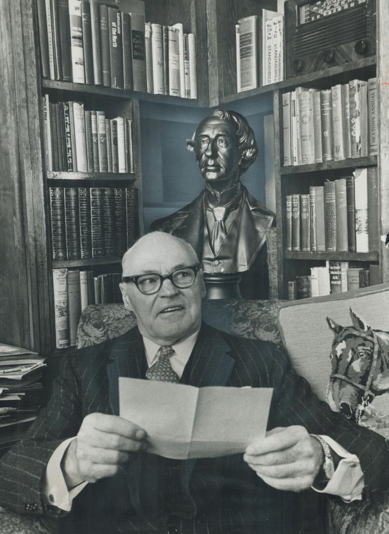 Hon. Earl Rowe relaxes in the study of his Simcoe county farmhouse. Room is dominated by bust and oils of Sir John A. Macdonald and Mr. Rowe's love of horses