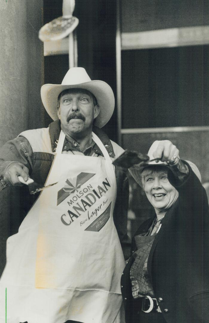 Flippin' good time: Calgary Alderman Barry Erskine gives Mayor June Rowlands a few lessons in pancake flipping at Nathan Phillips Square yesterday