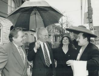 Help pours in. Royal Canadian Air Force veteran Roger Abbott, right, jokes in the rain with Cabbagetown Community Arts Company officials and boosters (...)