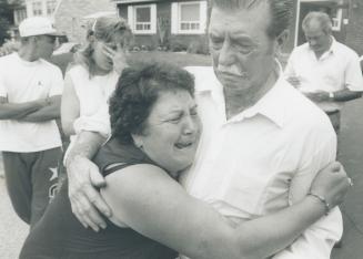 Mother's grief: Blanda Sabatino of Etobicoke takes comfort in a relative's arms after police shot her son Dominic, 32, yesterday