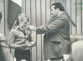 Everyone's heroine Elfi Schlegel, 16, first Canadian gymnast to win a medal in international competition, is presented with an eagle wood carving and (...)