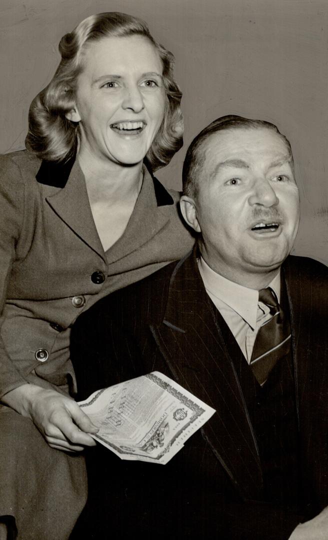 Charles W. A. Scott and his Canadian - born wife discussing the victory bond they'll buy when the fourth loan campaign begins monday. For six month no(...)