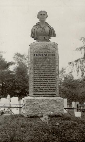 A monument to Laura Secord topped by a bust of her. Explanatory text appears on the monument (u…