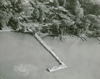 Wharf on mainland crowded with spectators to fire