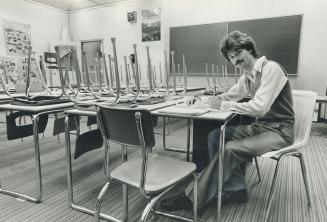 Staying after school: North York teacher Scott Bell marks papers in classroom after end of teaching day.