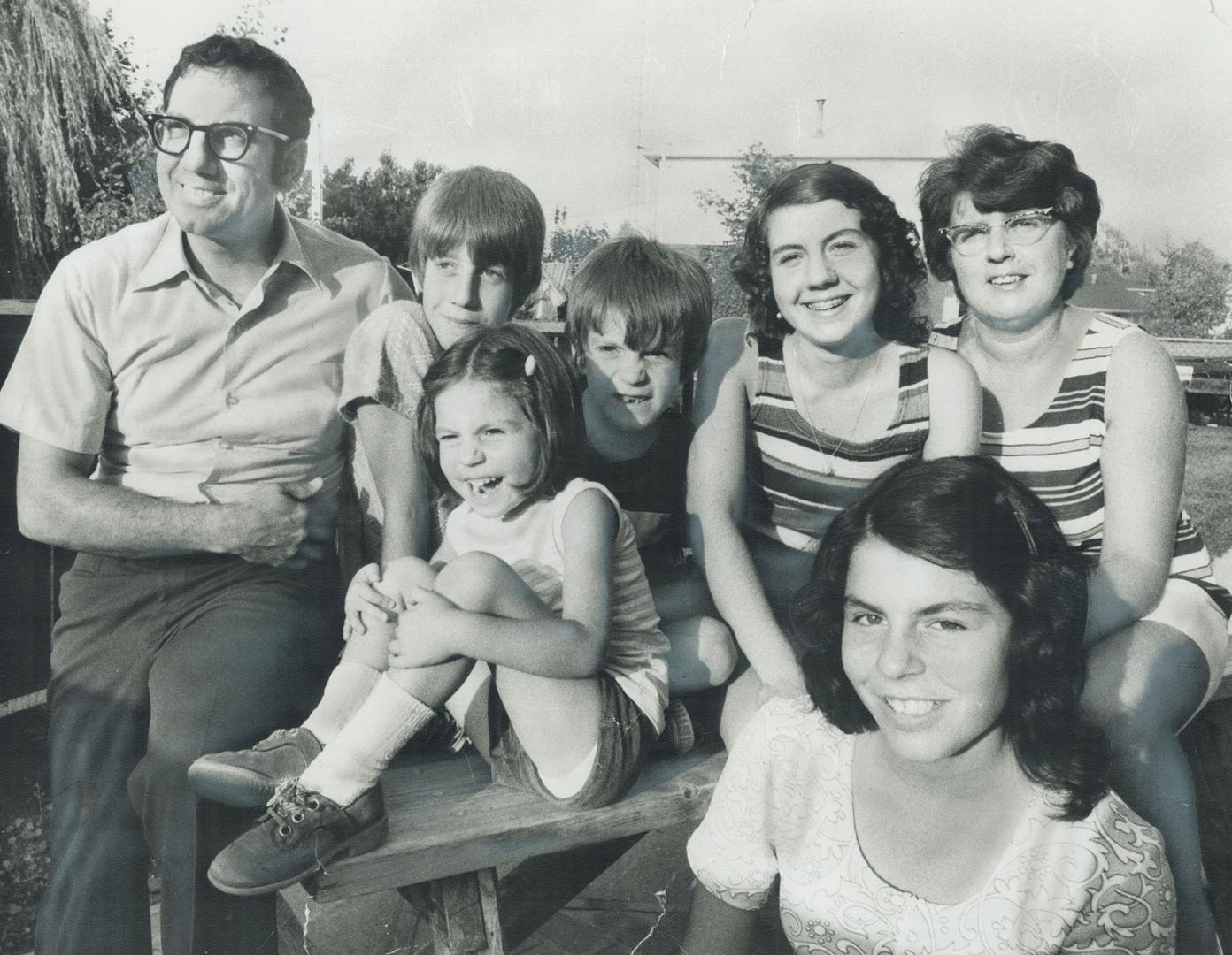 We believe that everything we do must be governed by religious principles, says Joseph Benedetto, left, who sends all his children to the St. Boniface Separate School. From left are Michael, 11, Suzanne, 4 (seated), Anthony, 7, Karen, 16, Mrs. Benedetto, and Jo-Anne, 13, in front. Their street is affectionately called Catholic Court because, with nine neighboring houses, it sends 42 children to St. Boniface school.