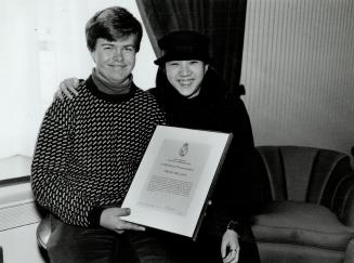 Teenaged hero honored, David Belisle, 16, of Ward's Island holds a commendation given to him yesterday by the Toronto Harbor Commission for saving Jane Kan, 16, right, and another girl after they rode their tandem bicycle off a dock.