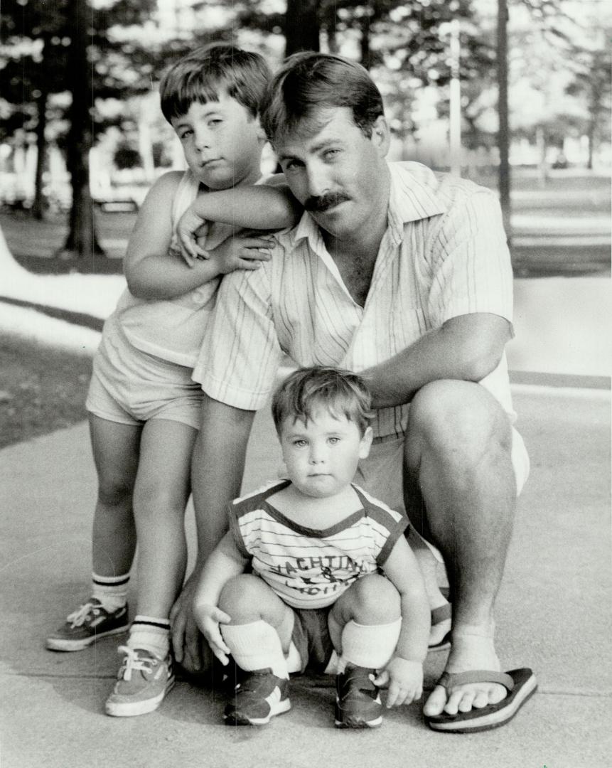 Exposed kids: Father Roger Beals says his two kids, Travis and Cameron, were soaked with poisonous insecticides when a Toronto parks worker, wearing a gas mask, began spraying trees around the Kew Gardens area.